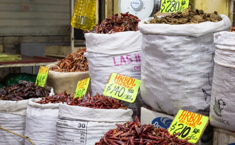 Bags of dried chilies for sale at a market in Mexico City, showcasing a colorful variety.