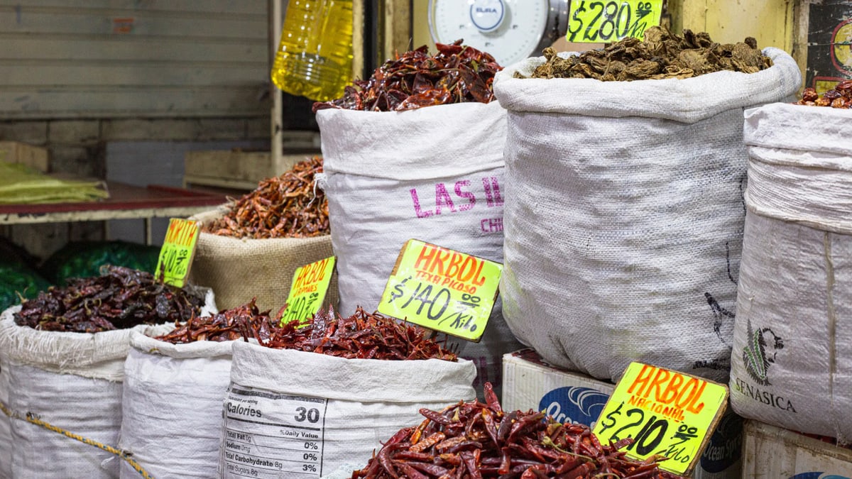 Bags of dried chilies for sale at a market in Mexico City, showcasing a colorful variety.
